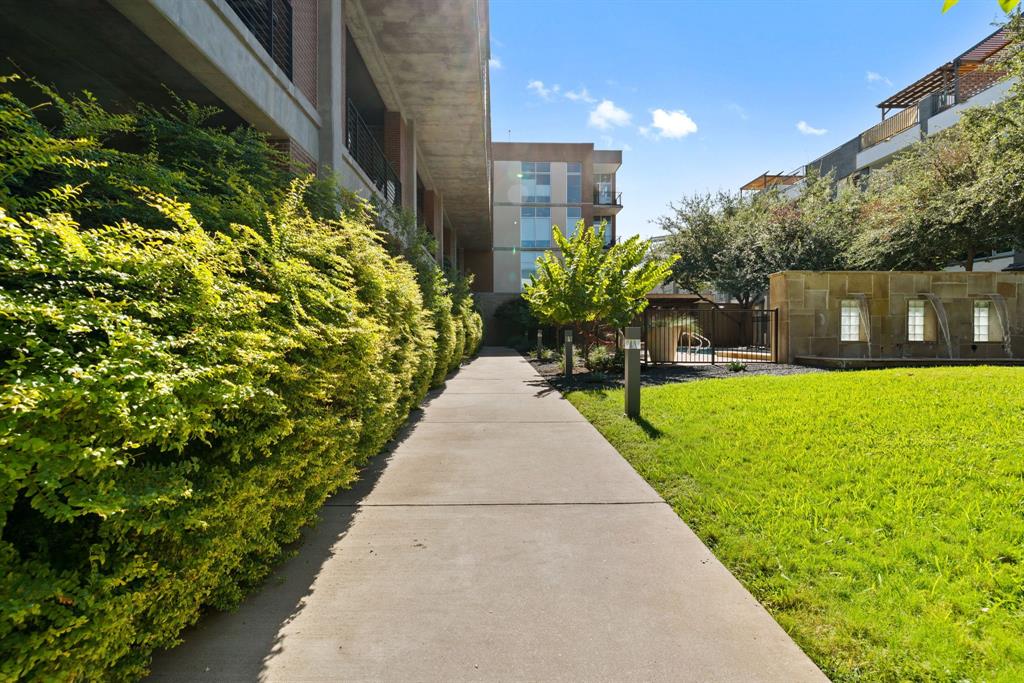 3030 Bryan Street, Unit 409 Dallas, TX 75204 - Photo 23 of 30 a view of a patio with table and chairs next to a yard