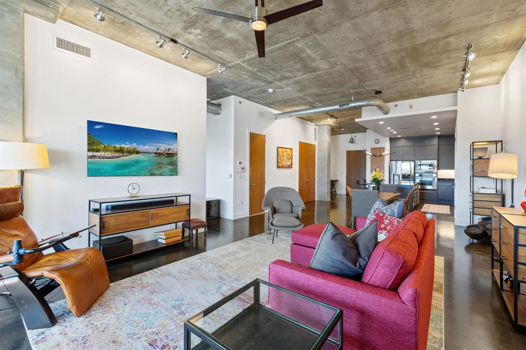 3030 Bryan Street, Unit 409 Dallas, TX 75204 - Photo 10 of 30 a living room with furniture a flat screen tv and a lamp