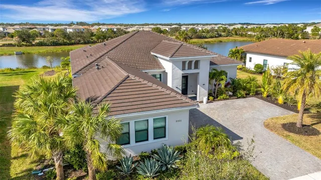an aerial view of a house with a yard and lake view