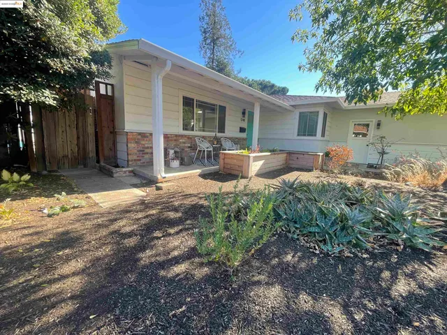 a backyard of a house with yard and outdoor seating