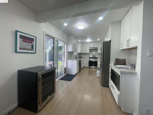 a kitchen with stainless steel appliances granite countertop a refrigerator a stove top oven a sink and dishwasher