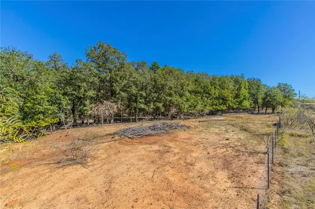 a view of a yard with trees in the background