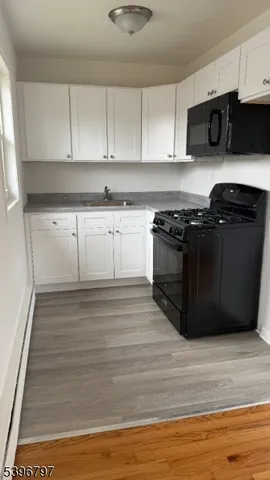 a kitchen with granite countertop a stove and a microwave