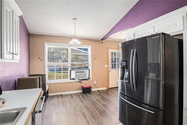 a kitchen with stainless steel appliances a refrigerator and wooden floor
