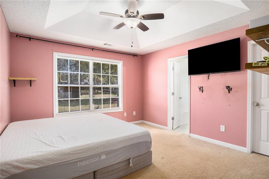1224 Dylan Way Bethlehem, GA 30620 - Photo 22 of 33 a bedroom with a large bed and a flat screen tv