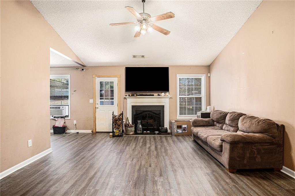 1224 Dylan Way Bethlehem, GA 30620 - Photo 6 of 33 a living room with furniture a fireplace and a flat screen tv