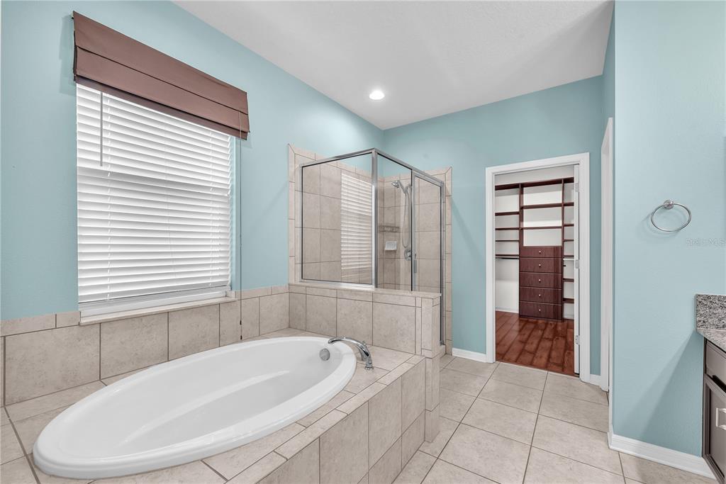 11236 77th Street East Parrish, FL 34219 - Photo 19 of 53 a bathroom with a bathtub and a shower