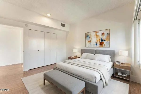 a bedroom with a bed and a painting on the wall