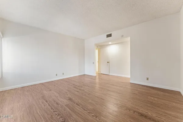 a view of an empty room with wooden floor