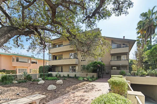a view of a brick house with a large windows and a large tree