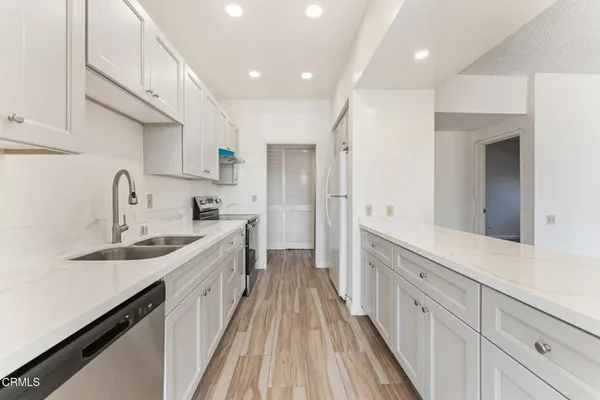 a kitchen with sink a stove and cabinets