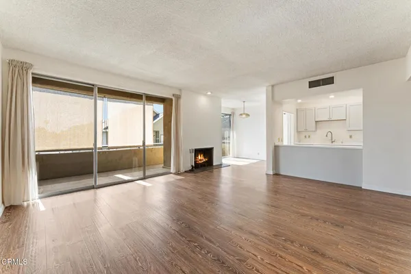 wooden floor fireplace and windows in an empty room