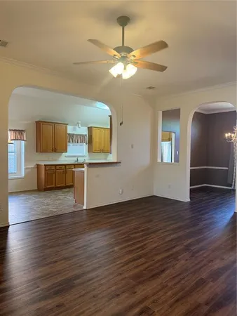 a view of a livingroom with wooden floor and a ceiling fan