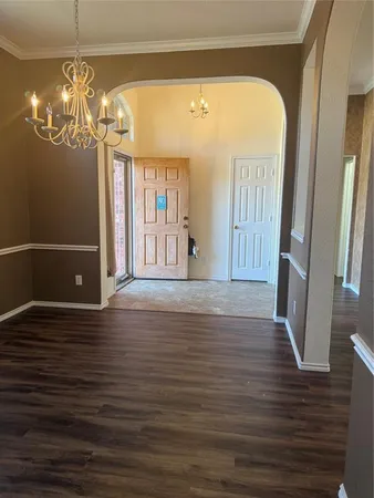 a view of a livingroom with wooden floor and chandelier