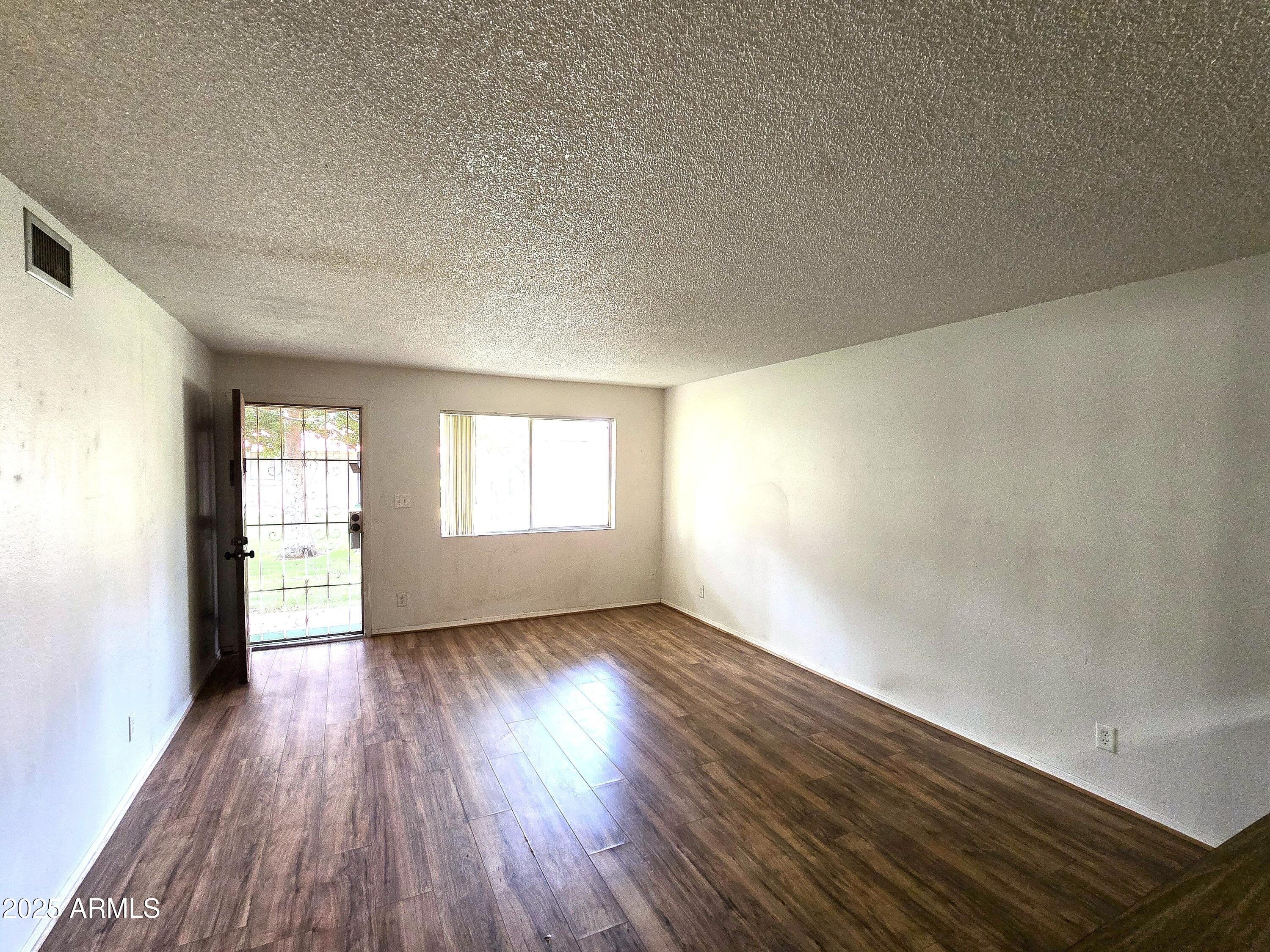 141 North Date, Unit 7 Mesa, AZ 85201 - Photo 4 of 15 an empty room with wooden floor and windows
