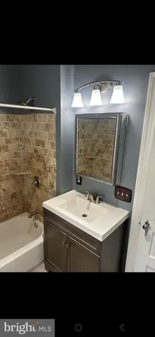 a bathroom with a sink a mirror and a bathtub
