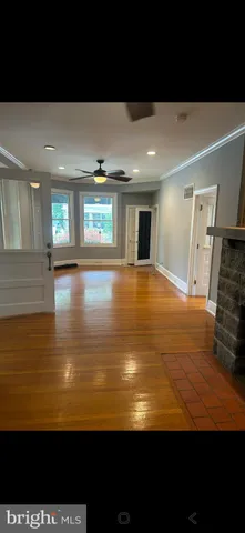 a view of a kitchen with an empty space and wooden floor