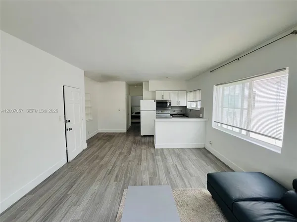 a kitchen with wooden floors and white cabinets
