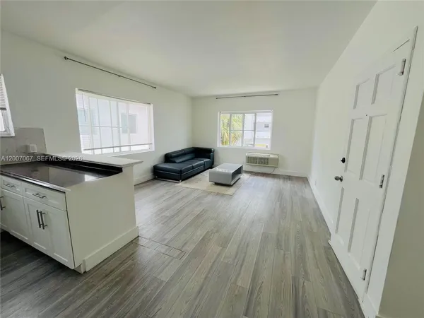 a kitchen with granite countertop a stove a sink and a refrigerator