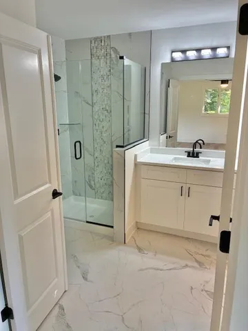 a bathroom with a shower sink and mirror
