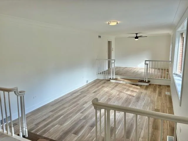 a view of empty room with wooden floor