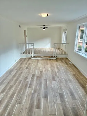 a view of empty room with wooden floor