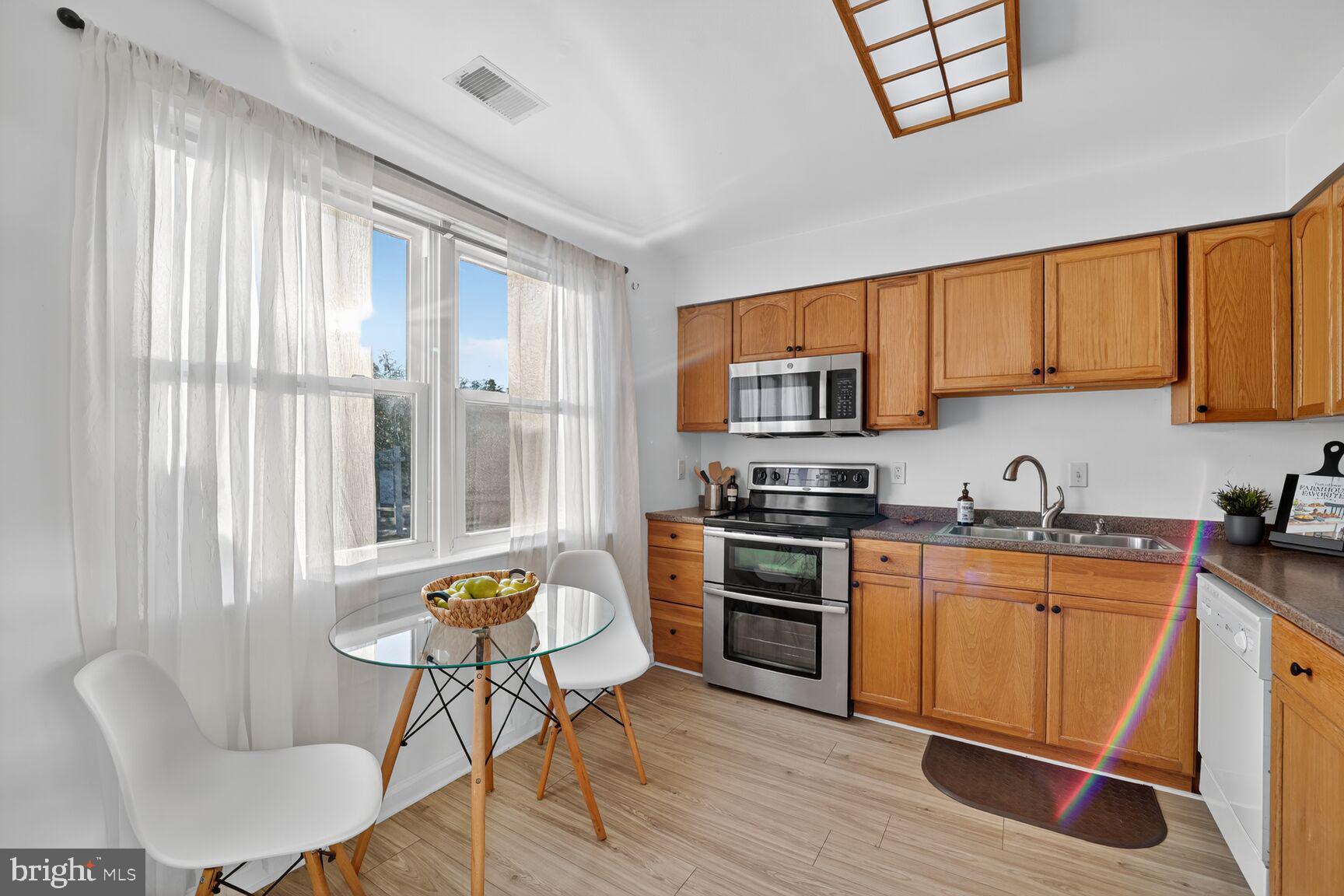 779 Match Point Drive Arnold, MD 21012 - Photo 2 of 28 a kitchen with stainless steel appliances granite countertop a stove top oven a sink dishwasher a dining table and chairs with wooden floor
