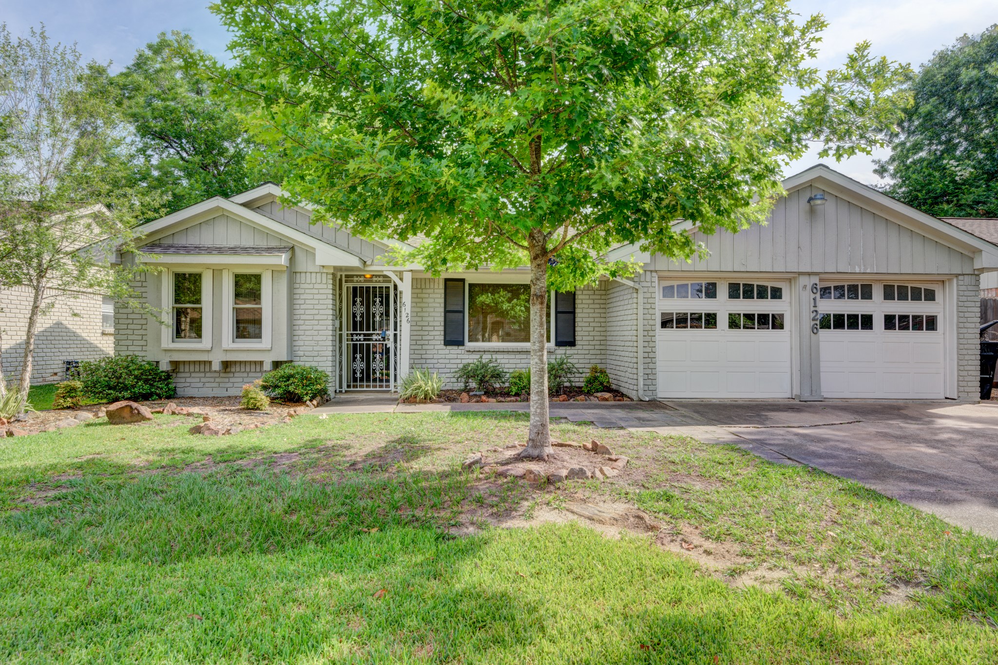 a front view of a house with a garden and yard