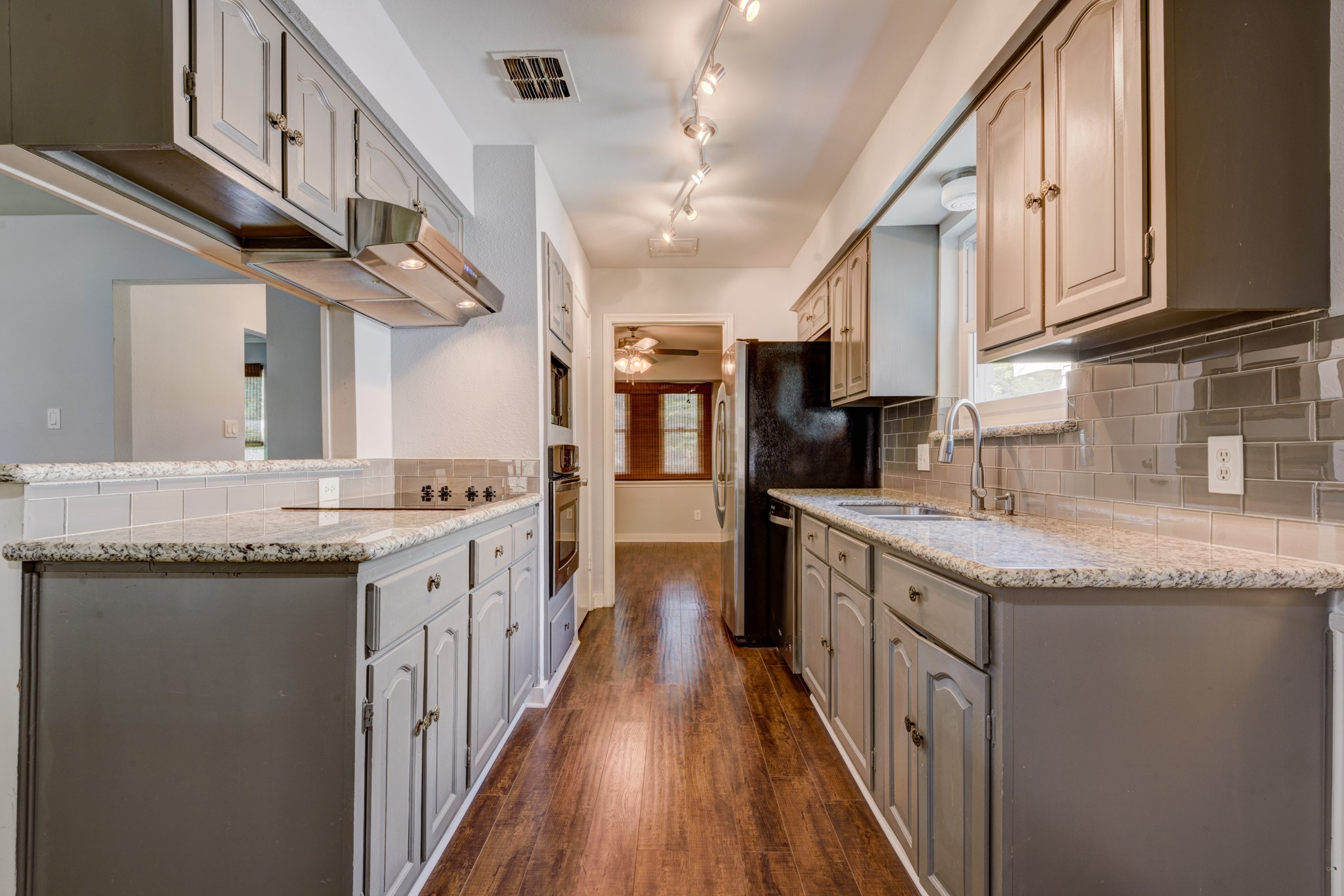 6126 Rena Street Houston, TX 77092 - Photo 12 of 24 a kitchen with stainless steel appliances granite countertop a sink a stove and a wooden floors