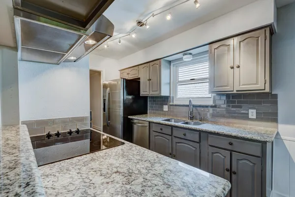 a kitchen with stainless steel appliances granite countertop a sink stove and refrigerator