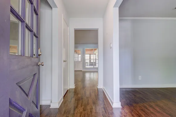 a view of a hallway with wooden floor and staircase