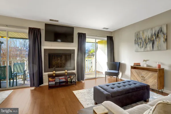 a living room with furniture a flat screen tv and a large window