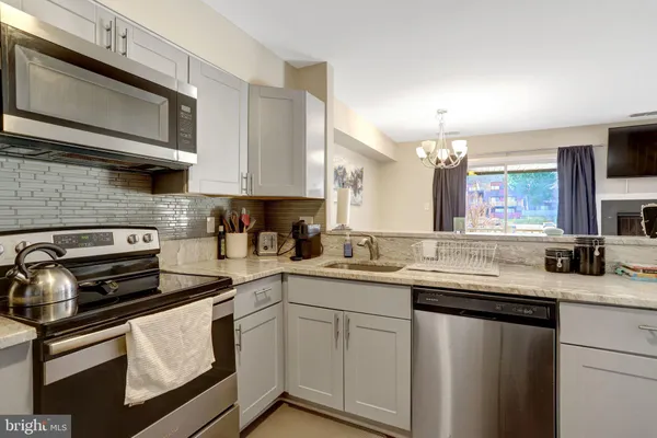 a kitchen with stainless steel appliances granite countertop a sink stove and microwave
