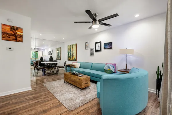 a living room with furniture and a wooden floor