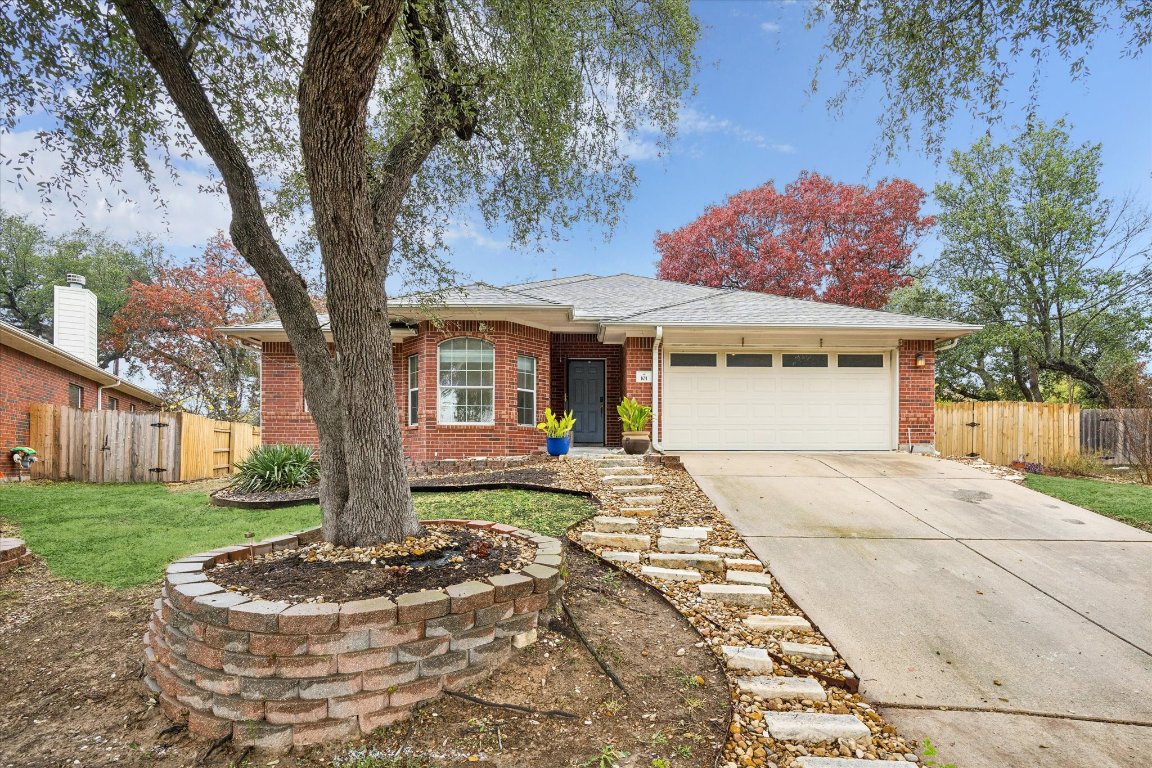Ranch-style home featuring brick siding, concrete driveway, and an attached garage