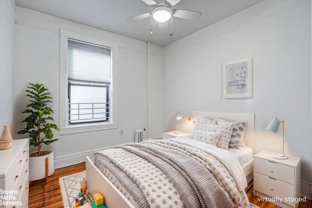 35-45 82nd Street, Unit 4 Queens, NY 11372 - Photo 6 of 15 a bedroom with a bed and a chandelier