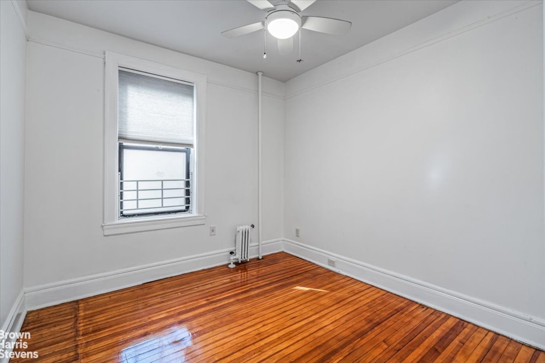35-45 82nd Street, Unit 4 Queens, NY 11372 - Photo 8 of 15 an empty room with wooden floor and windows