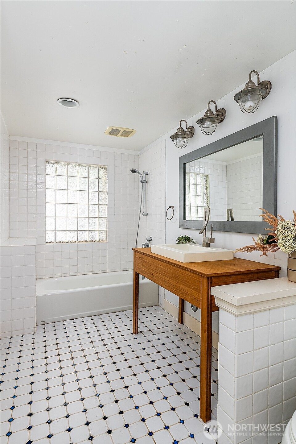 9521 25th Avenue Northwest Seattle, WA 98117 - Photo 9 of 29 a spacious bathroom with a sink a toilet a mirror and shower
