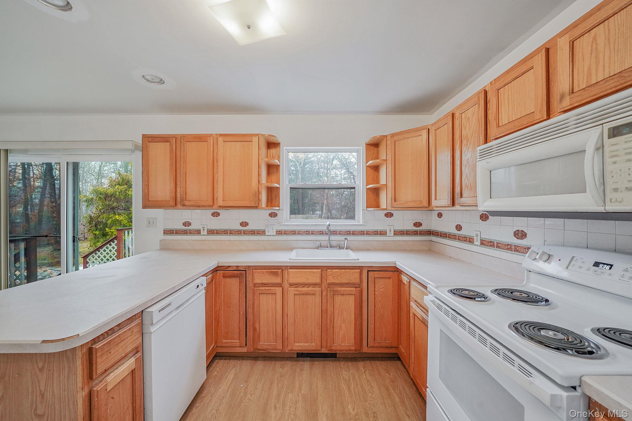 22 Wright Road Manorville, NY 11949 - Photo 13 of 47 a kitchen with a sink stove and cabinets