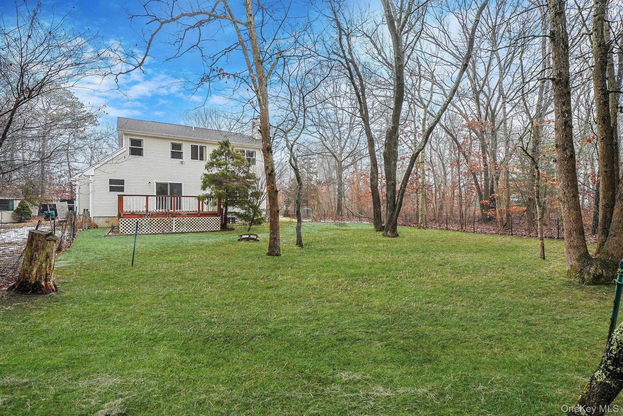 22 Wright Road Manorville, NY 11949 - Photo 34 of 47 a view of a white house with a big yard and large trees