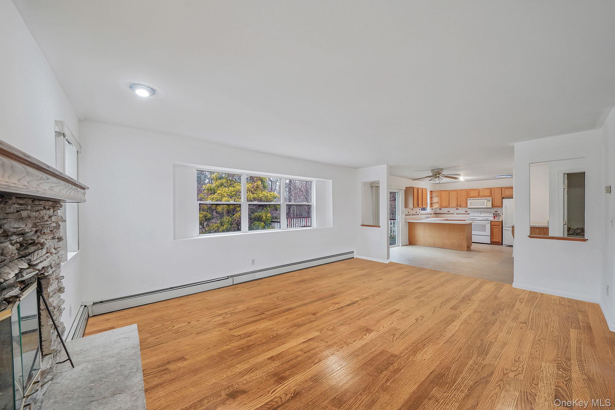 22 Wright Road Manorville, NY 11949 - Photo 10 of 47 a view of an empty room with a window and wooden floor