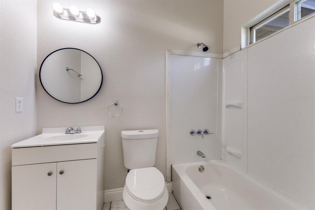 711 South 3rd Avenue East Dawson, TX 76639 - Photo 8 of 12 a bathroom with a bathtub sink vanity mirror and toilet