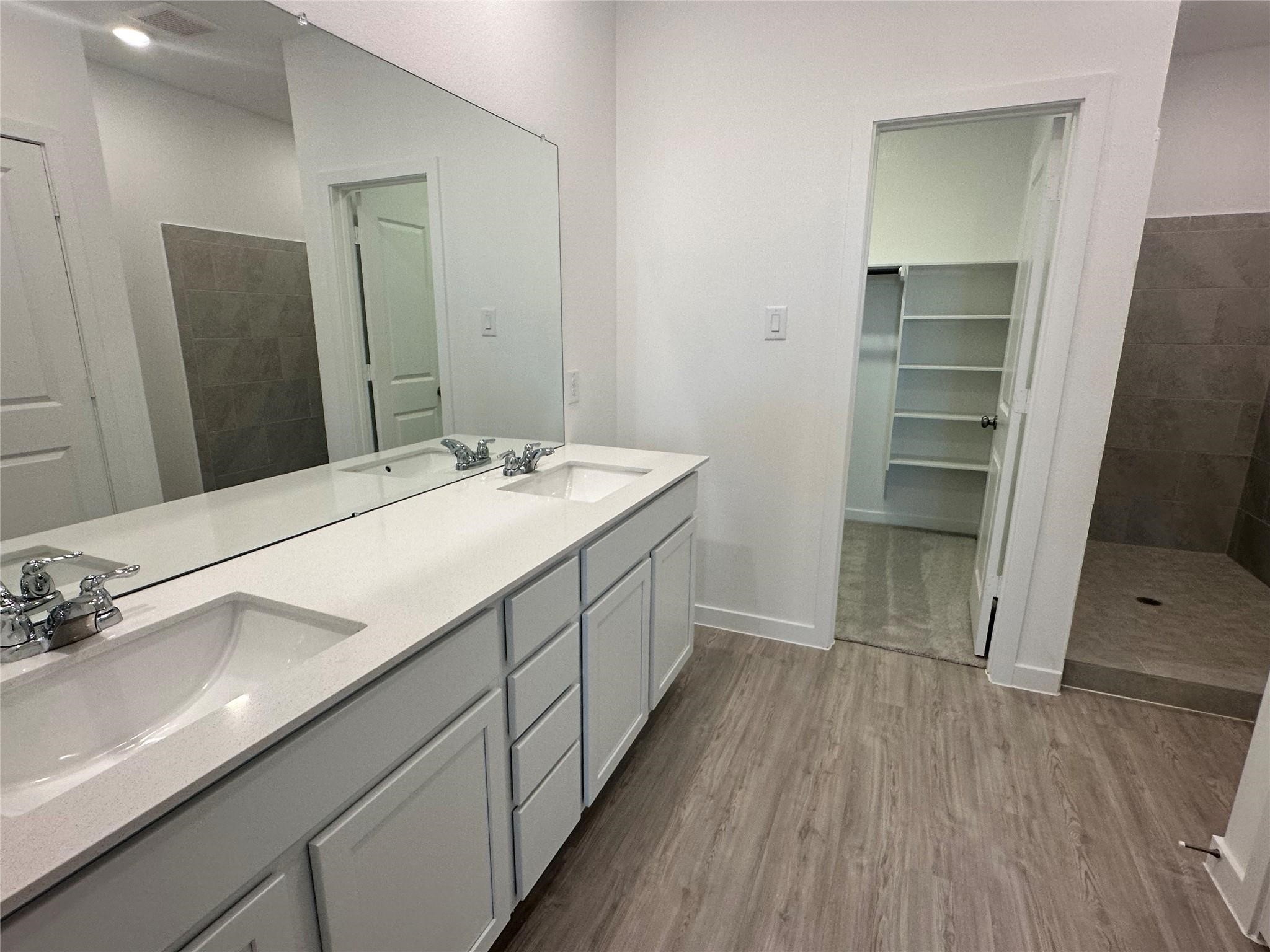 8310 Opal Pond Drive Angleton, TX 77515 - Photo 12 of 22 a spacious bathroom with a double vanity sink and a mirror