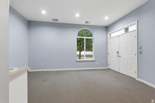 702 Alpine Highway Alpine, UT 84004 - Photo 57 of 83 Spacious room featuring a prominent arched window, double entry doors with a transom window, recessed ceiling lighting, and light-colored carpeting