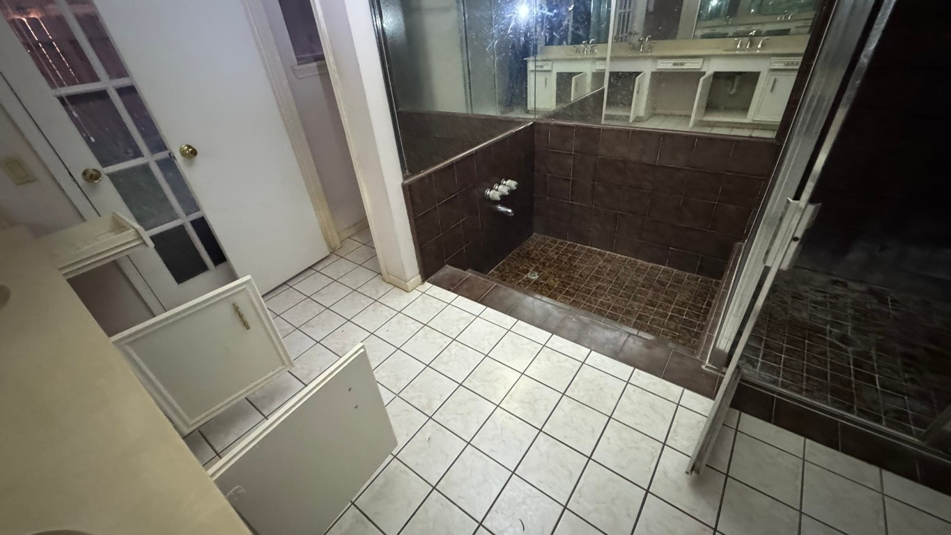 2162 Paso Rello Drive Houston, TX 77077 - Photo 21 of 32 a bathroom with a granite countertop sink and glass door