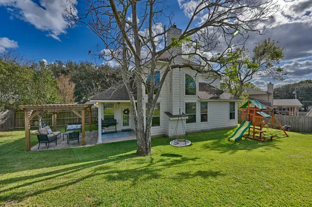 a view of a chair and table in backyard of the house