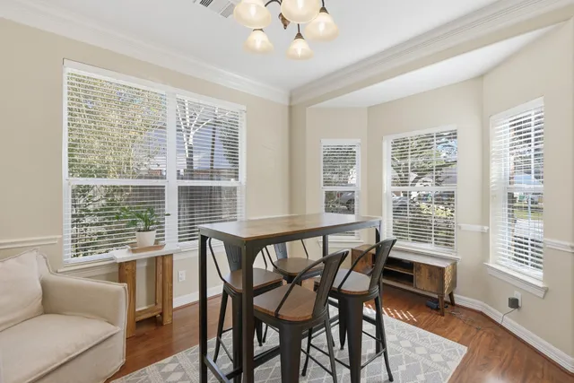 a view of a dining room with furniture large windows and wooden floor