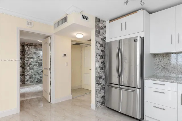 a view of a kitchen with refrigerator and cabinet