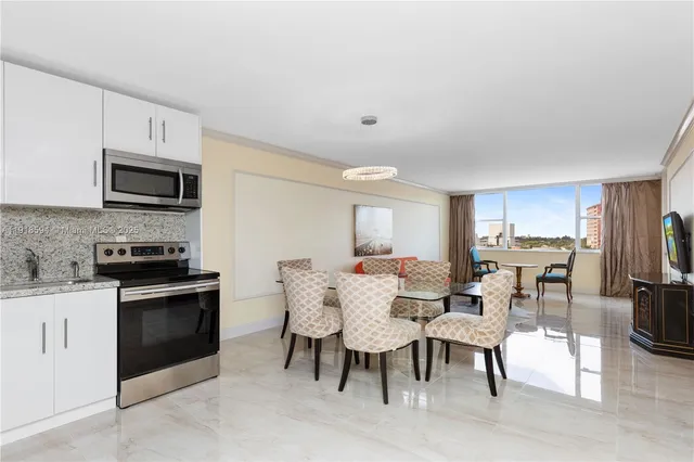 a view of kitchen with microwave stove top oven and cabinets