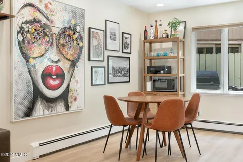 a kitchen with stainless steel appliances a table and chairs in it